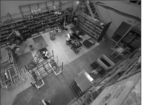 Två produktionsarbetare går i fabriksområdet med AprilTags på hårdhattar och tröjor för rörelsespårning med Viscando 3D&AI.